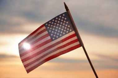 Yakın plan Amerikan bayrağı arkadan gelen güneş ışığıyla gökyüzünde dalgalanıyor. Amerika Birleşik Devletleri bayrağı - geri aydınlandı. 4 Temmuz - Bağımsızlık Günü