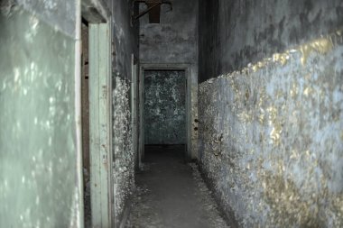 Terk edilmiş evde uzun bir koridor, hasarlı duvarlar ve kapılar, çatlak boyalar. Terk edilmiş otelin eski koridoru, yıkılmış bina. Kimse..