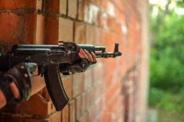 Askerî silahlar erkeklerin elinde. siyah deri eldivenler.