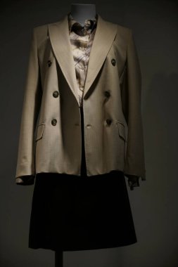 bej gömlek, gri ceket ve siyah etek manken üzerinde, beyaz arka planda izole. dükkan penceresi