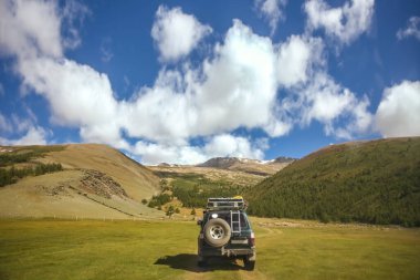 MOUNTAIN ALTAI, RUSSIA - 22 HAZİRAN 2017: patikadaki dağlarda SUV arabası. Güneşli yaz zamanı. arka plan.  