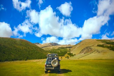 MOUNTAIN ALTAI, RUSSIA - 22 HAZİRAN 2017: patikadaki dağlarda SUV arabası. Güneşli yaz zamanı. arka plan.  