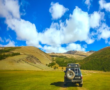 MOUNTAIN ALTAI, RUSSIA - 22 HAZİRAN 2017: patikadaki dağlarda SUV arabası. Güneşli yaz zamanı. arka plan.  