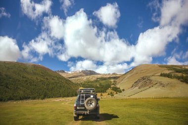 MOUNTAIN ALTAI, RUSSIA - 22 HAZİRAN 2017: patikadaki dağlarda SUV arabası. Güneşli yaz zamanı. arka plan.  
