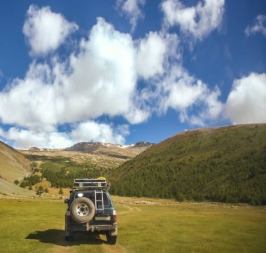 MOUNTAIN ALTAI, RUSSIA - 22 HAZİRAN 2017: patikadaki dağlarda SUV arabası. Güneşli yaz zamanı. arka plan.  