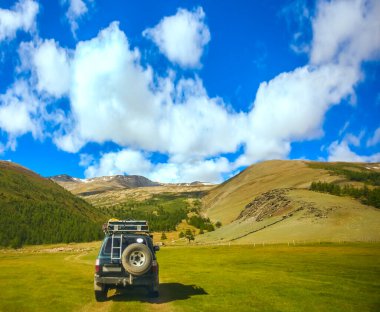 MOUNTAIN ALTAI, RUSSIA - 22 HAZİRAN 2017: patikadaki dağlarda SUV arabası. Güneşli yaz zamanı. arka plan.  