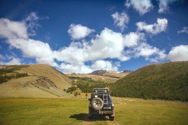 MOUNTAIN ALTAI, RUSSIA - 22 HAZİRAN 2017: patikadaki dağlarda SUV arabası. Güneşli yaz zamanı. arka plan.  