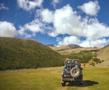 MOUNTAIN ALTAI, RUSSIA - 22 HAZİRAN 2017: patikadaki dağlarda SUV arabası. Güneşli yaz zamanı. arka plan.  