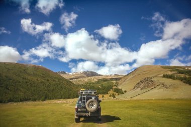 MOUNTAIN ALTAI, RUSSIA - 22 HAZİRAN 2017: patikadaki dağlarda SUV arabası. Güneşli yaz zamanı. arka plan.  