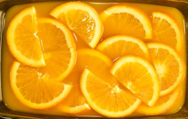 Portakal suyunda taze portakal dilimleri. içecek arka planında izole