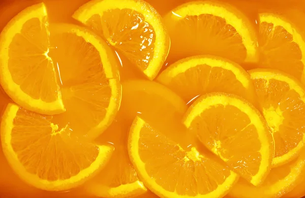 fresh many orange slices in orange juice . isolated on beverage background
