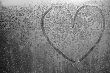 Donmuş bir kış penceresinde çizilmiş bir kalp..