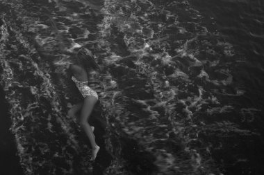  Kadın, cennet gibi tropik plajda dinleniyor. Dalgalar üzerine vururken kumlu sahilde uzanıyor.. 