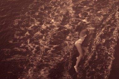  Kadın, cennet gibi tropik plajda dinleniyor. Dalgalar üzerine vururken kumlu sahilde uzanıyor.. 