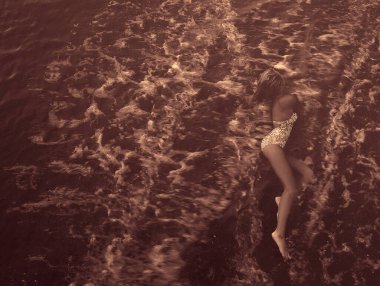  Kadın, cennet gibi tropik plajda dinleniyor. Dalgalar üzerine vururken kumlu sahilde uzanıyor.. 