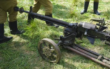 Ağır makineli tüfek. Eski güçlü askeri makineli tüfek. Uzun namlulu. Asker ayakta duruyor..