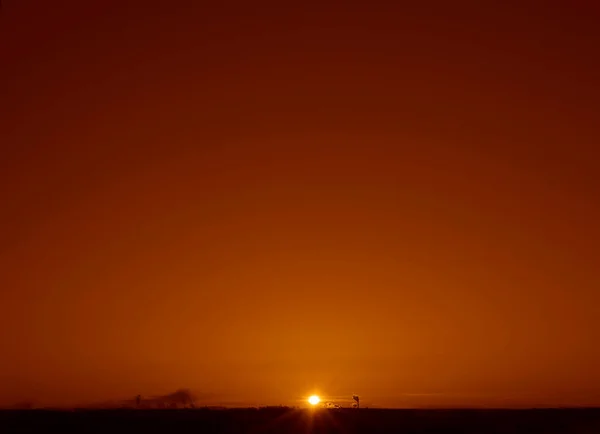 Dark  silhouettes of industrial pipes with smoke. rays of the setting sun. Sunrise in the city. Silhouette City landscape in the backlight of the sunset.