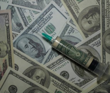 İçinde 100 dolarlık banknotların olduğu bir şırınga. Her şeyi gören gözü olan bir piramit.