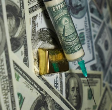 İçinde 100 dolarlık banknotların olduğu bir şırınga. Her şeyi gören gözü olan bir piramit. altın külçesi