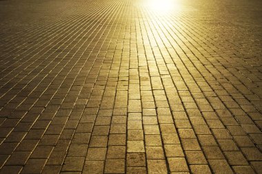 Gün batımında kaldırım. Cobbled Stones 'da güneş ışığı. Güneş ışığı ve güneş ışınları. boş arkaplan Yaya yürüyüşü. asfalt döşemeler