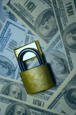 Altın külçeler asma kilit ve dolarların arka planında. Altın rezervi fikri