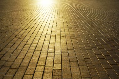 Gün batımında kaldırım. Cobbled Stones 'da güneş ışığı. Güneş ışığı ve güneş ışınları. boş arkaplan Yaya yürüyüşü. asfalt döşemeler