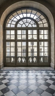 İçi desenli zemin ve büyük yuvarlak pencereli taş duvarlarla dolu. Tarihsel iç mekan. Louvre, Paris