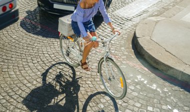 Şoförlü bir kadın bisiklete biniyor. Trafik sıkışık. PARIS, FRANSA 