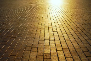 Gün batımında kaldırım. Cobbled Stones 'da güneş ışığı. Güneş ışığı ve güneş ışınları. boş arkaplan Yaya yürüyüşü. asfalt döşemeler