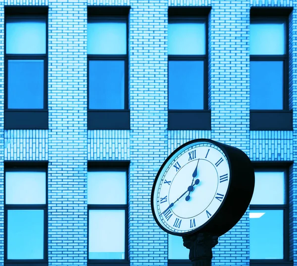 Clock of office building. Modern round clock in the background of brick building. time is money idea.