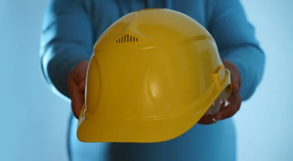 Male Hands with yellow safety helmet. Human Hands holding hard hat, Isolated