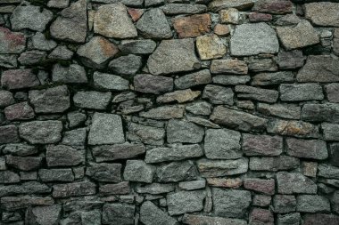 Taş bir duvarın dokusu. Eski kale taşından duvar dokusu. Arka plan ya da doku olarak taş duvar. Bir taş duvarın parçası, arkaplan veya doku için.