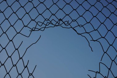 Hasar kablosu mavi gökyüzü arka planında. Mavi arkaplanda izole edilmiş delikle ağ örgüsü            