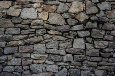 Taş bir duvarın dokusu. Eski kale taşından duvar dokusu. Arka plan ya da doku olarak taş duvar. Bir taş duvarın parçası, arkaplan veya doku için.