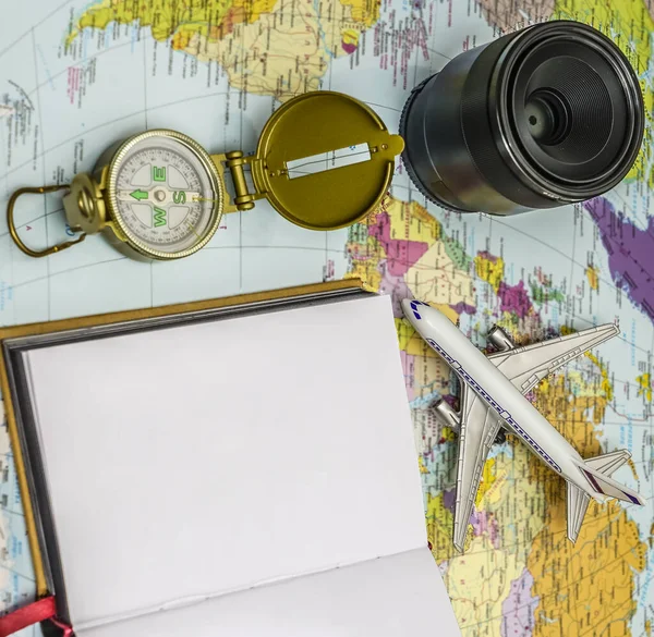 Travel background concept. objective with plane and compass,  empty white paper for text. world map on background.