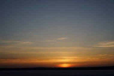 Sunset on lake with sun setting down behind the mountains