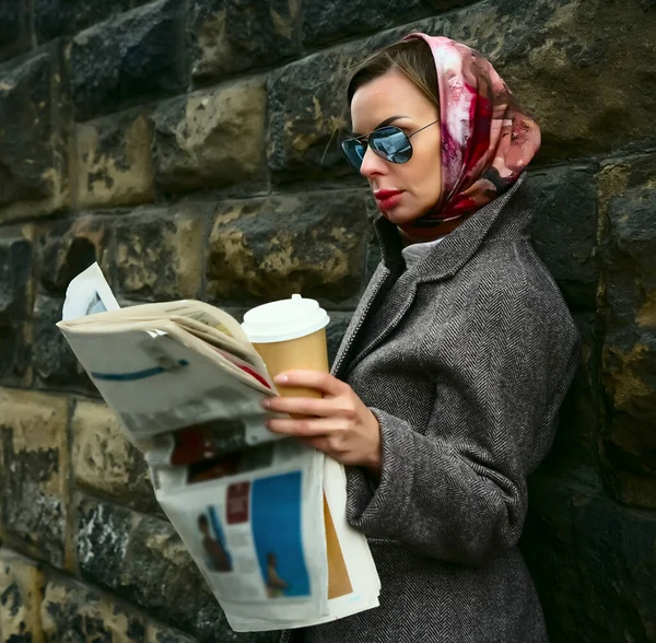 Stilvoller Schicker Frauenstand Mit Heißem Kaffeebecher Zum Mitnehmen Und Zeitung Stockfoto