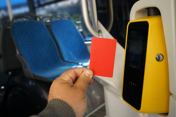 male Hand Using Bus Pass For Journey. paying in the bus. A man on a bus pays for fare with an electronic card using a validator