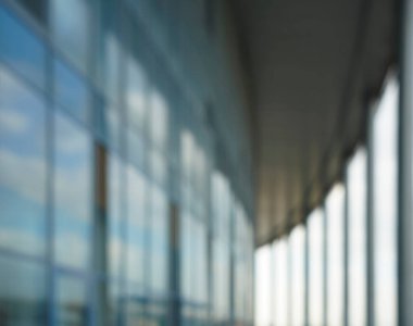 Binanın arka planındaki bulanık mavi cam duvar. Ofisin arka planındaki bulanık ofis lobisi. İç mekan boş. Cam duvardan gelen bulanık ışık var. 