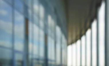 Binanın arka planındaki bulanık mavi cam duvar. Ofisin arka planındaki bulanık ofis lobisi. İç mekan boş. Cam duvardan gelen bulanık ışık var. 