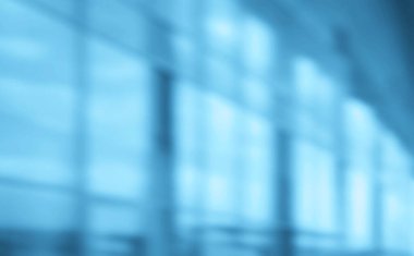 Binanın arka planındaki bulanık mavi cam duvar. Ofisin arka planındaki bulanık ofis lobisi. İç mekan boş. Pencereden gelen bulanık ışık.