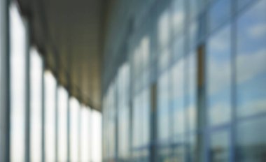 Binanın arka planındaki bulanık mavi cam duvar. Ofisin arka planındaki bulanık ofis lobisi. İç mekan boş. Cam duvardan gelen bulanık ışık var. 