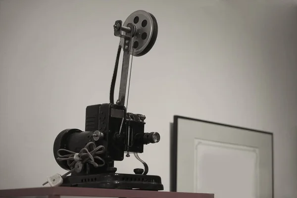 Movie projector on a white and black  background with wire and plug.