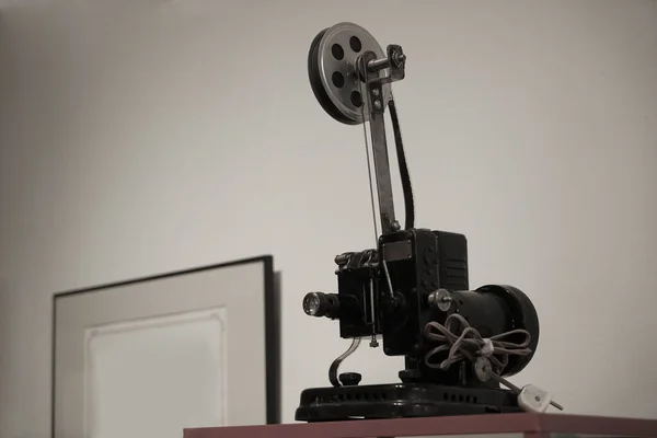 Movie projector on a white and black  background with wire and plug.
