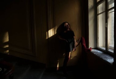 Pencere kenarında duran uzun saçlı, rüya gören bir kadın.. 