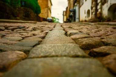 Taş ve güneş ışığı. Eski sokak zemininde asfalt var. Avrupa 'da sokak fayansları ve yürüyen insanlar. Kaldırımlar. Avrupa 'daki evlere karşı kaldırımlı taşlar. Vyborg, Leningrad bölgesi