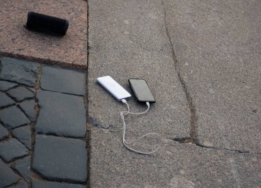 Mobil cihaz ve cihazları şarj etmek için güç bankası. Güç bankası olan siyah akıllı telefon şarj aleti. Kablosuz hoparlör için dış pil