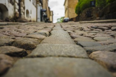 Taş ve güneş ışığı. Eski sokak zemininde asfalt var. Avrupa 'da sokak fayansları ve yürüyen insanlar. Kaldırımlar. Avrupa 'daki evlere karşı kaldırımlı taşlar. Vyborg, Leningrad bölgesi