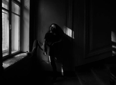 Pencere kenarında duran uzun saçlı, rüya gören bir kadın.. 