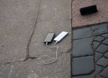 Mobil cihaz ve cihazları şarj etmek için güç bankası. Güç bankası olan siyah akıllı telefon şarj aleti. Kablosuz hoparlör için dış pil